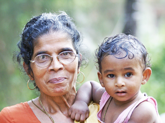 older adult holding young grandchild outside