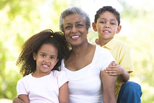 older adult sitting in between two children