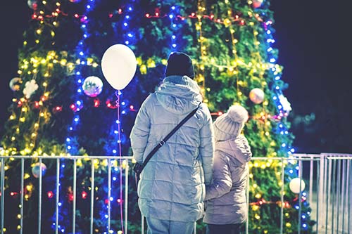 adult and child looking at decorated tree