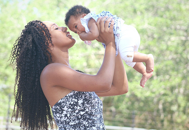 mother holding up infant child