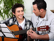 father and child plaing guitar