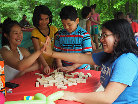 adults and children playing game at picnic