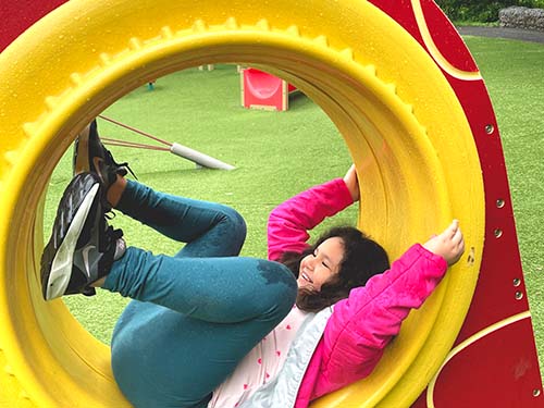 child playing inside tubular structure