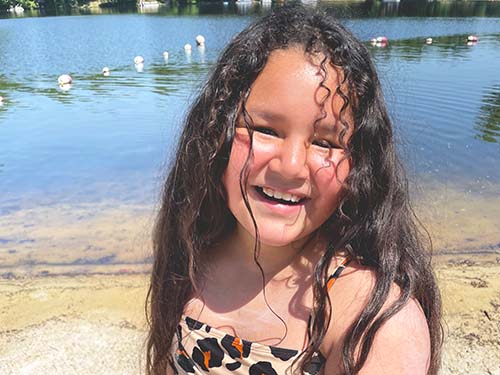 child smiling playing at water and beach area