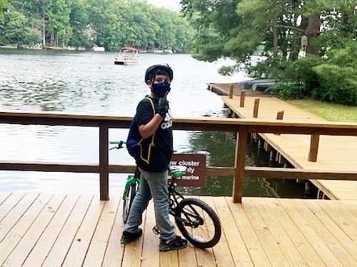 child with bicycle at lake