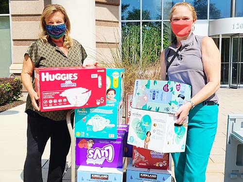 LiveWell diaper drive two people standing next to diaper boxes