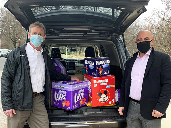 Dewberry two people standing next to car trunk with boxes of diapers