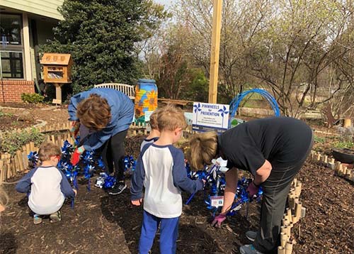 children and adults planting pinwheels