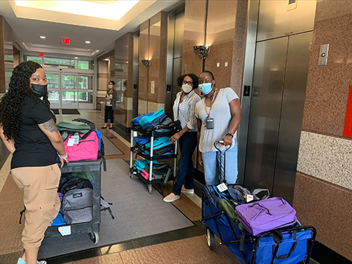 staff with donated backpacks