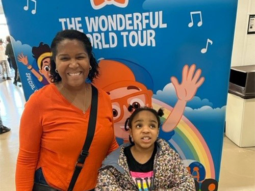 BAC mentor and mentee standing in front of Blippi sign