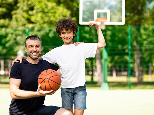 man and boy at basketball court