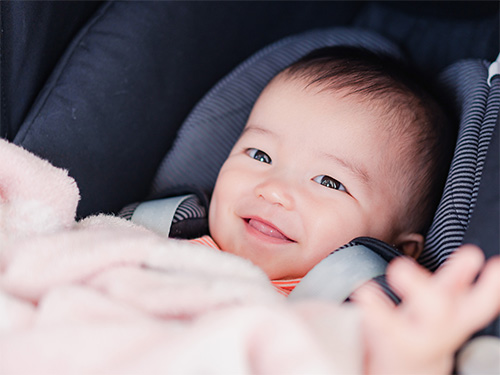 baby in car seat with pink blanket