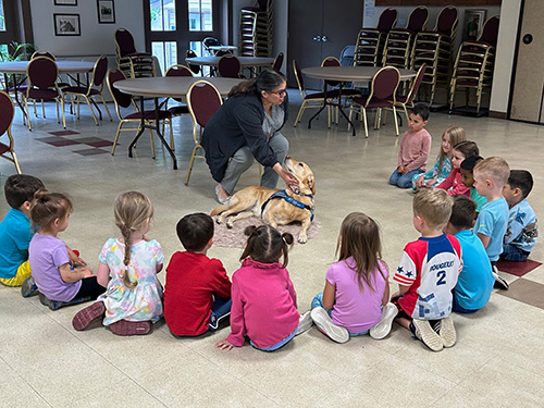 group of children sitting in circle looking at Rylynn
