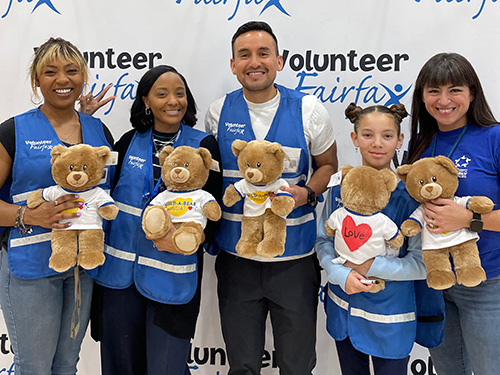 Volunteer and Partner Services staff holding stuffed bears