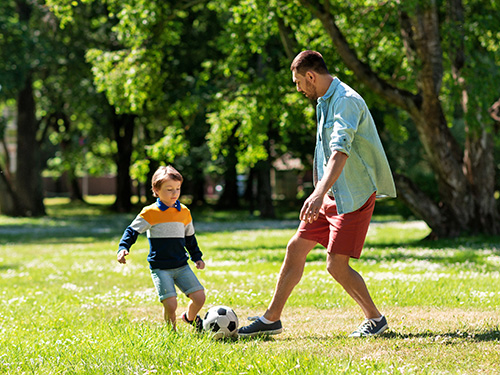 man and boy playing soccer