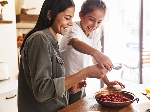 woman and girl eating strawberries