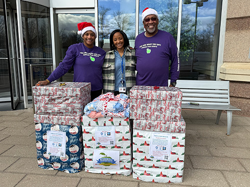 donors with gifts wearing santa hats