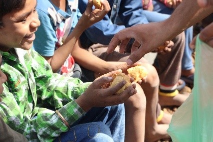 volunteer giving food to child