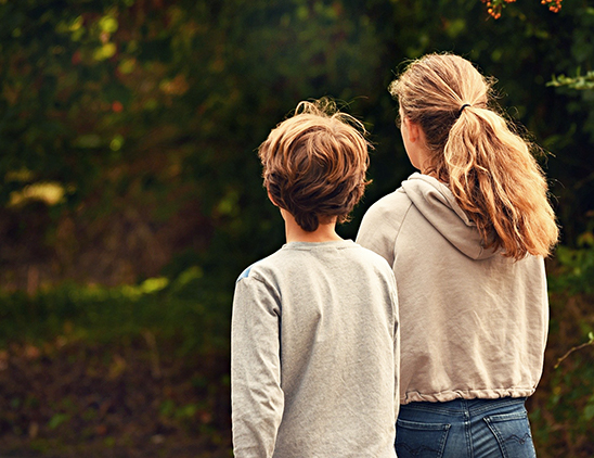 adult and child outside walking away side by side