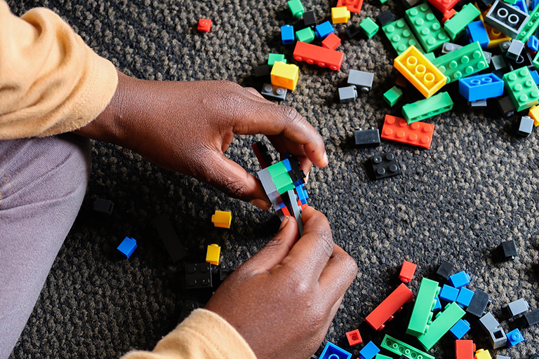 child hands playing with miniature block toys