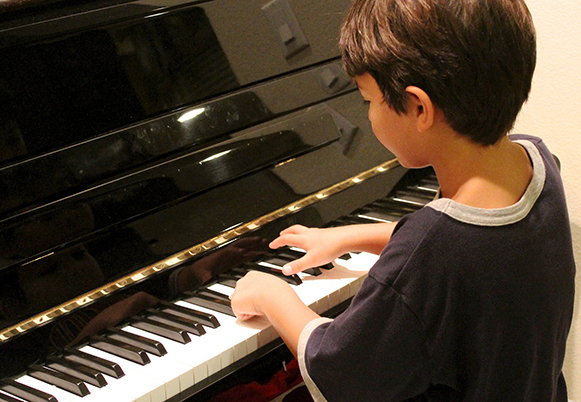 child sitting playing piano