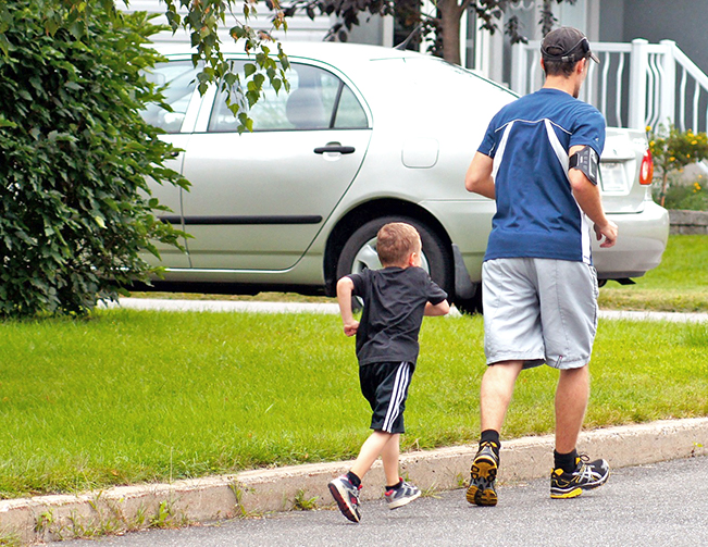 father and son walking and running on road
