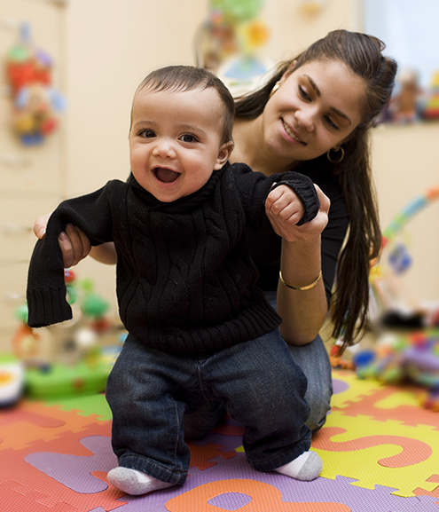 parent holding child learning to walk