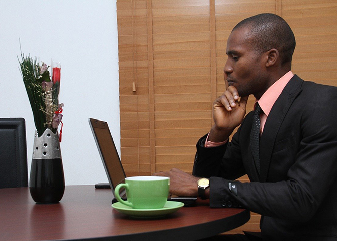person sitting at desk looking at laptop