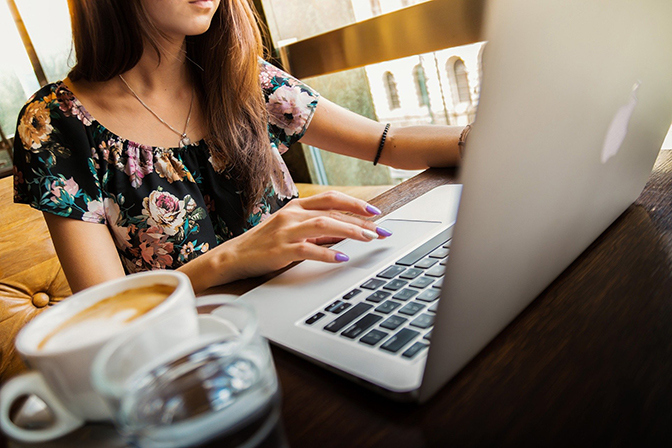 person sitting at table using laptop