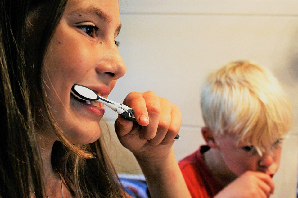 two children brushing teeth in bathroom