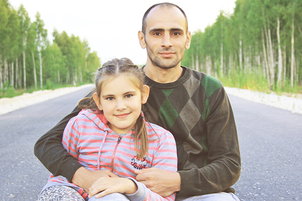 parent sitting holding child sitting on pavement