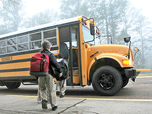 two children waiting to get on school bus