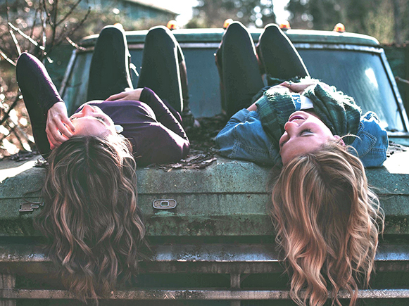 two people talking on truck hood