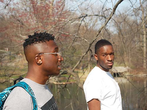 two people outside walking around park pond