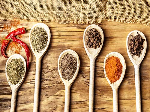 variety of spices in spoons on table