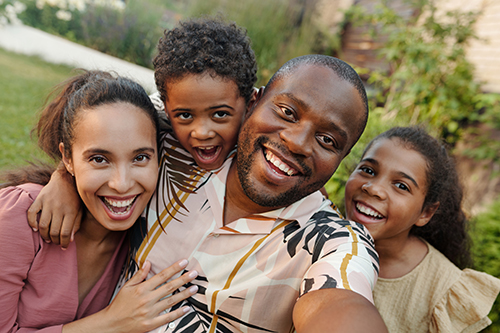 family smiling for selfie