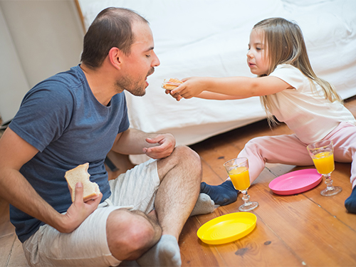 child feeding dad sandwich