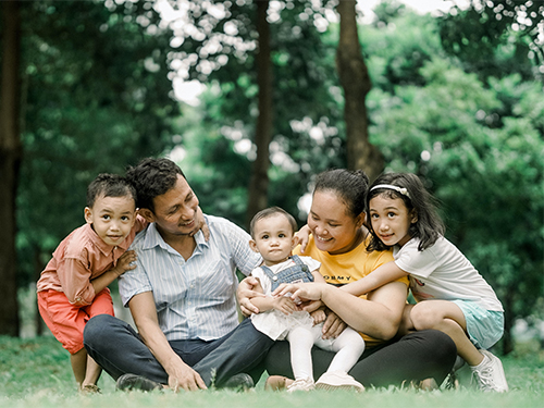 family sitting outside hugging