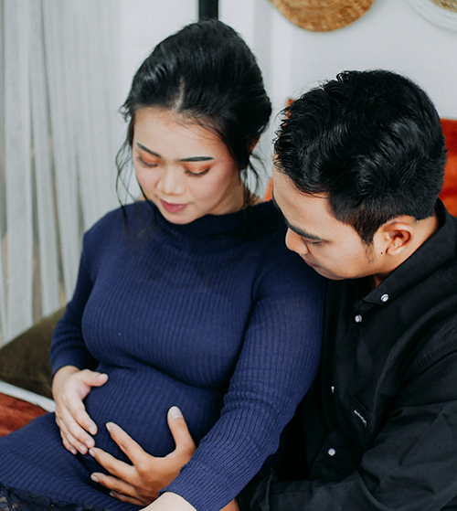 Man and woman holding pregnant stomach