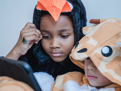 boys in animal costumes holding tablet