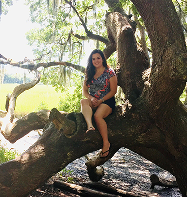 Brittany Vera sitting on large tree