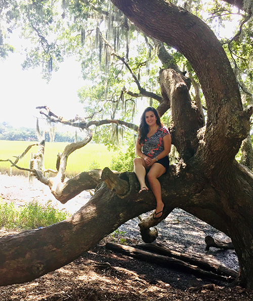 Brittany Vera sitting on large tree