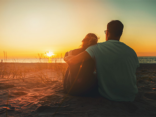 two people sitting on beach