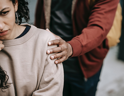 woman sitting with hand on shoulder 