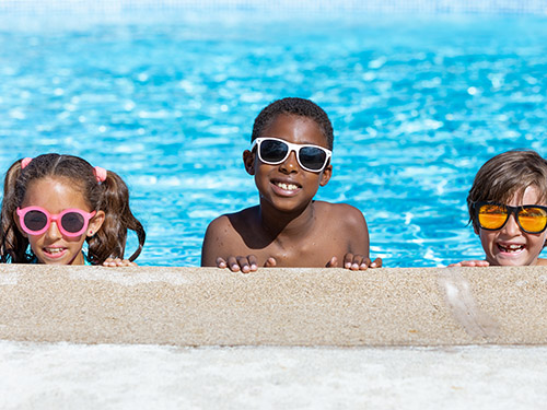 three children at edge of pool