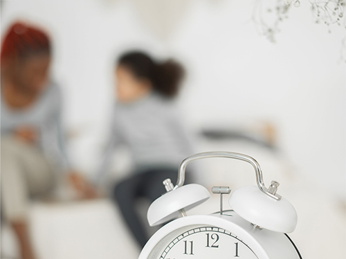 clock with woman and daughter in background