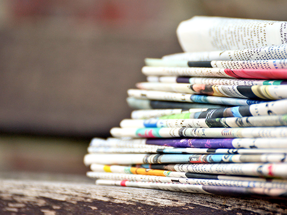 stack folded newspapers on table