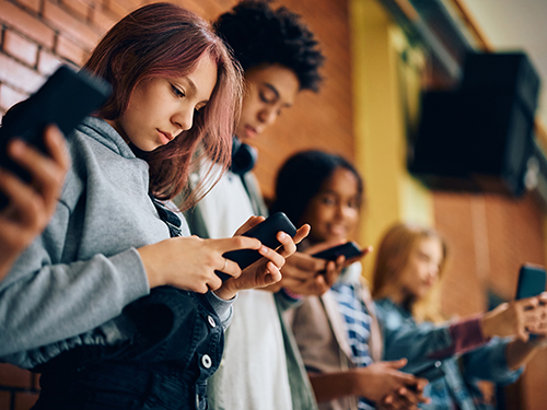 teens looking down at cell phones