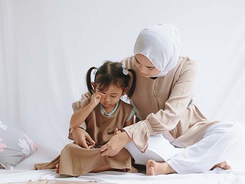 mom helping crying daughter