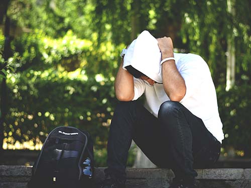 person sitting on ground looking down